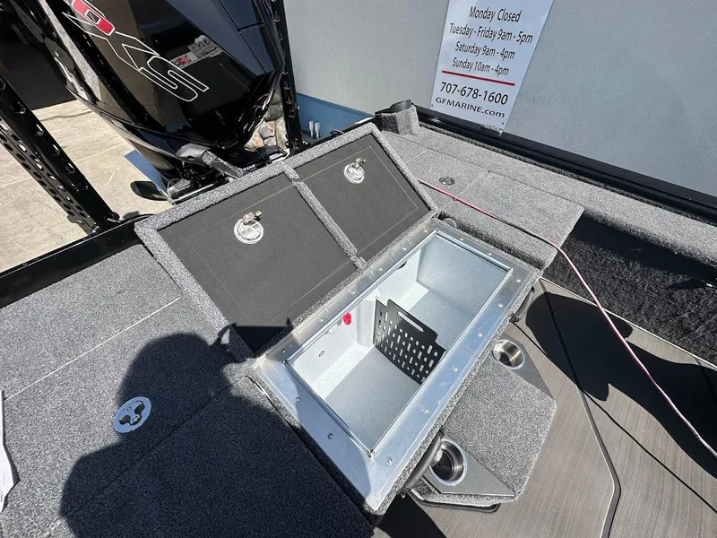 Slide: The Image of 2025 Lund 2075 Pro-V Bass XS boat with open storage compartment and motor. - 12