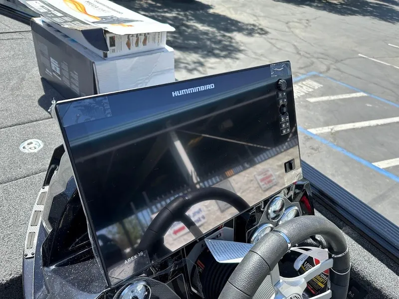 Slide: The Image of 2025 Lund 2075 Pro-V Bass XS boat dashboard with Humminbird display in parking lot. - 24