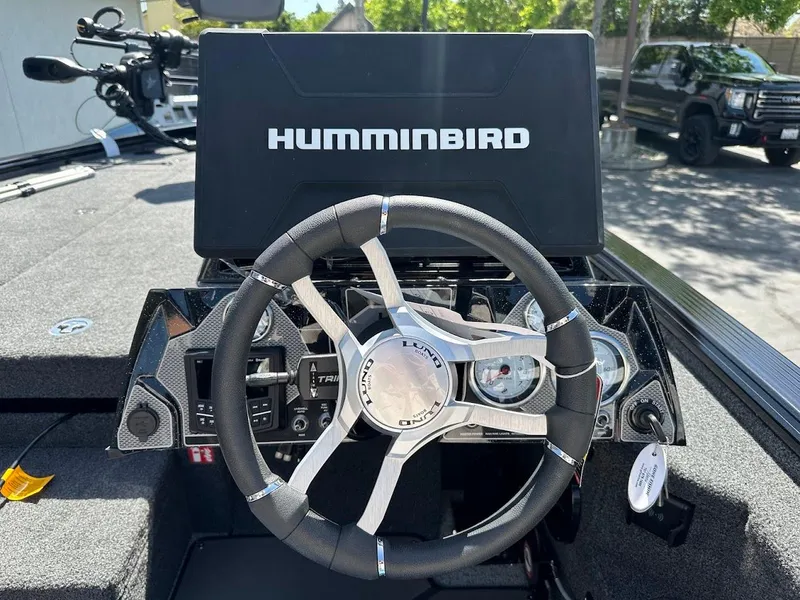 Slide: The Image of 2025 Lund 2075 Pro-V Bass XS dashboard with Humminbird display and steering wheel. - 26