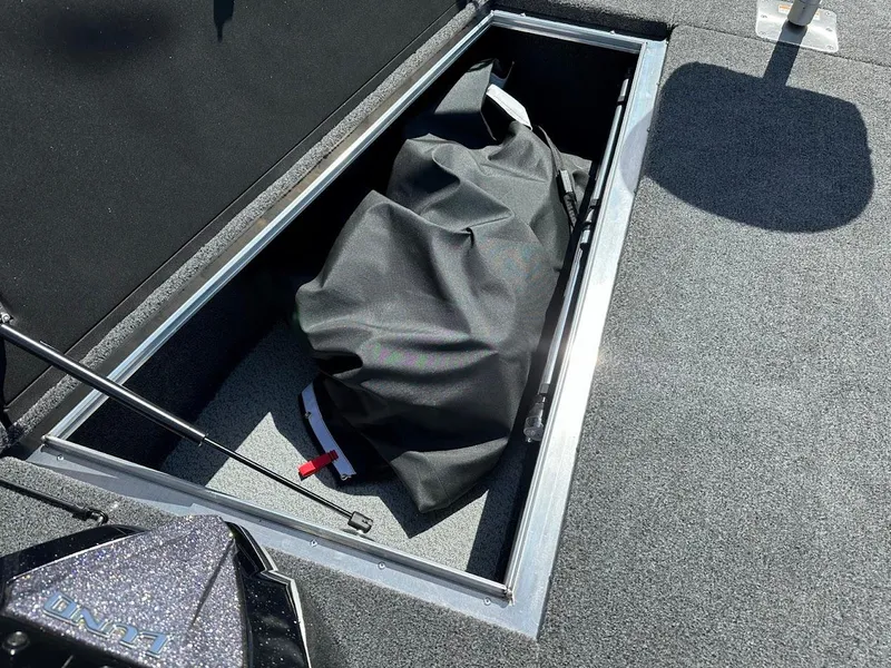 Slide: The Image of Storage compartment in 2025 Lund 2075 Pro-V Bass XS boat, featuring a black cover. - 35