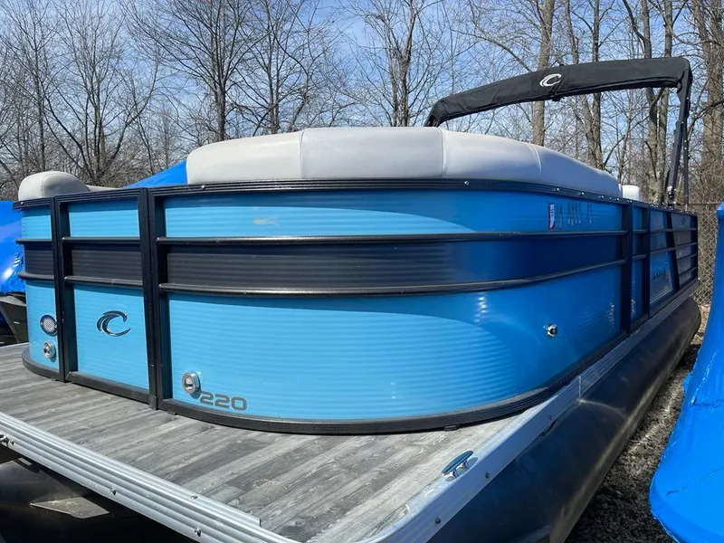 Slide: The Image of 2019 Crest Classic Platinum 220 SLRC pontoon boat in vibrant blue, docked outdoors. - 2