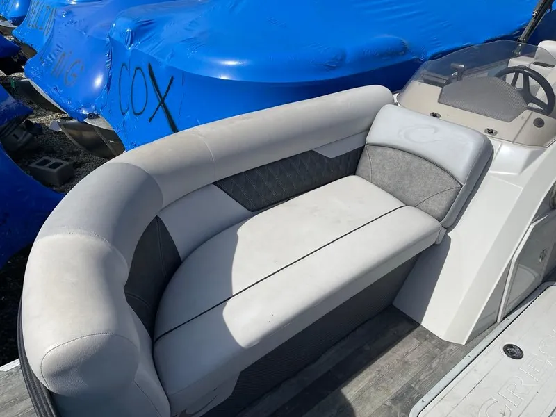 Slide: The Image of 2019 Crest Classic Platinum 220 SLRC boat with gray seating and blue covers in background. - 4
