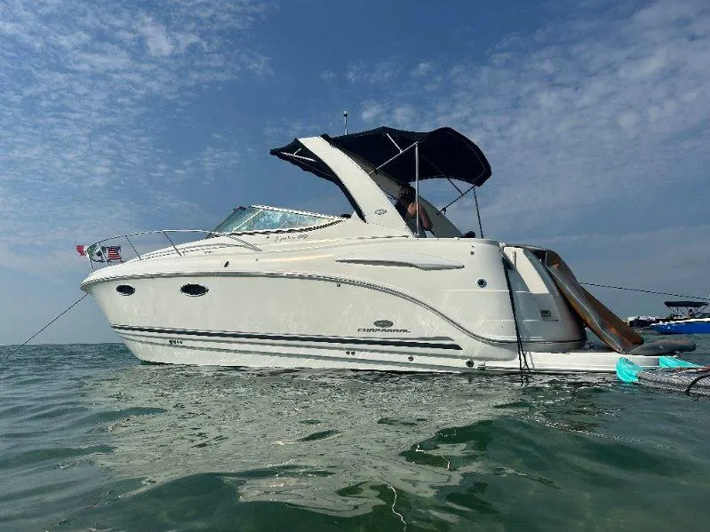 The Image of 2006 Chaparral 310 Signature boat on water under clear sky. - 0