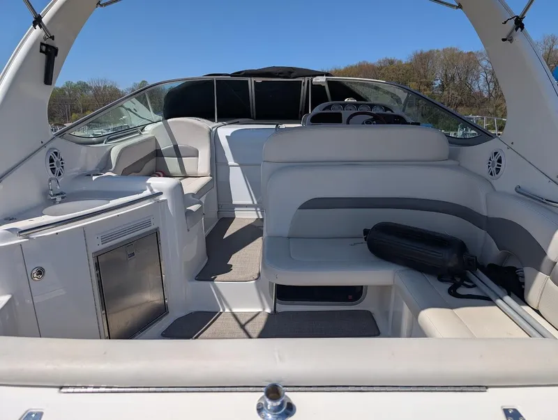 Slide: The Image of 2006 Chaparral 310 Signature boat interior with seating and storage, under clear blue sky. - 15