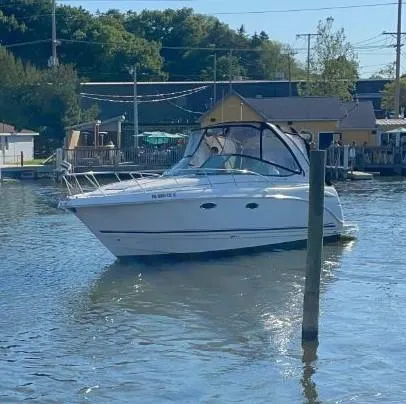 Slide: The Image of 2006 Chaparral 310 Signature boat docked in a serene marina setting. - 2