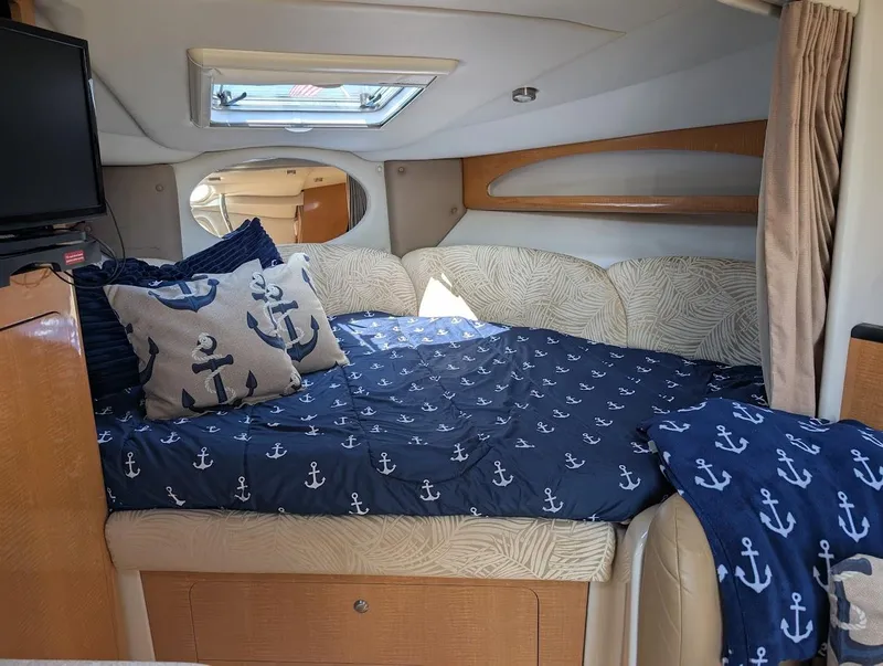 Slide: The Image of Interior of 2006 Chaparral 310 Signature with nautical-themed bedding and cozy cabin space. - 21