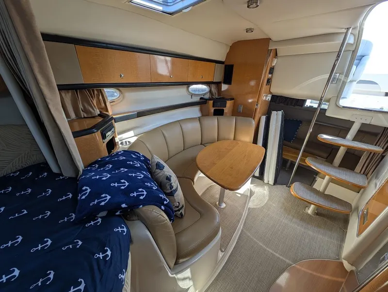 Slide: The Image of Interior of 2006 Chaparral 310 Signature boat with cozy seating and wooden table. - 23