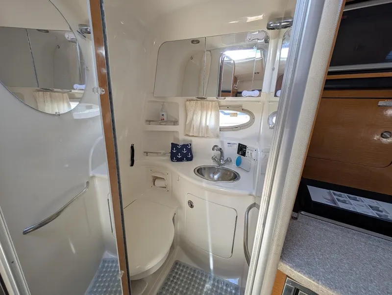 Slide: The Image of 2006 Chaparral 310 Signature boat bathroom with sink, toilet, and mirror. - 25