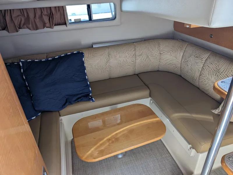 Slide: The Image of 2006 Chaparral 310 Signature cabin interior with beige seating and wooden table. - 30