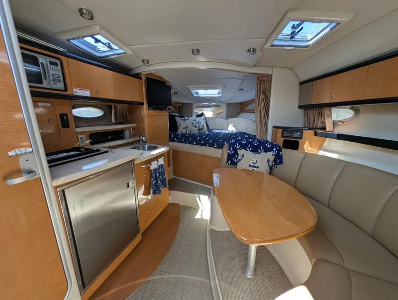 Slide: The Image of 2006 Chaparral 310 Signature interior with kitchen, seating, and cozy sleeping area. - 33