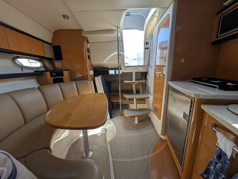 Slide: The Image of 2006 Chaparral 310 Signature yacht interior with dining area, kitchenette, and stairs. - 34