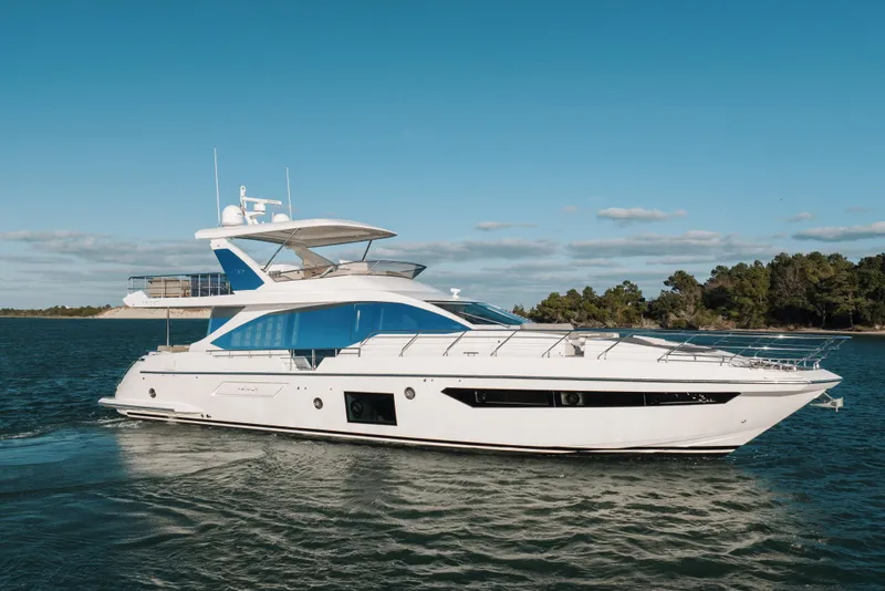 Slide: The Image of Luxury 2021 Azimut 72 yacht cruising on a serene waterway under a clear blue sky. - 1