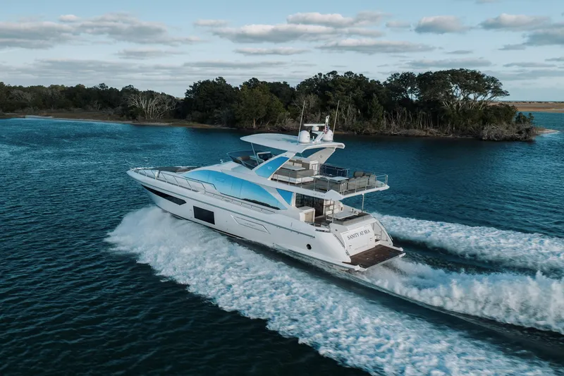 Slide: The Image of Luxury 2021 Azimut 72 yacht cruising on serene waters near a lush island. - 8
