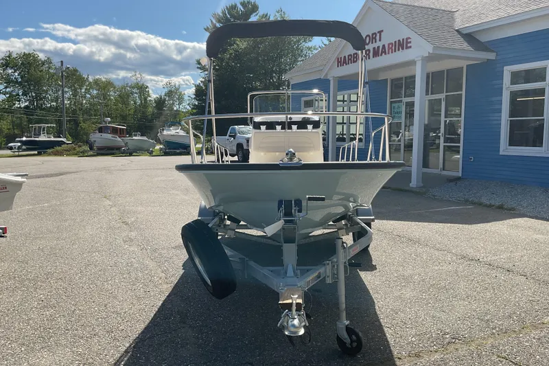 Slide: The Image of 2025 Boston Whaler 150 Montauk boat on trailer outside marine store. - 2