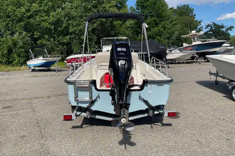Slide: The Image of 2025 Boston Whaler 150 Montauk boat with 60 HP engine, parked outdoors. - 5
