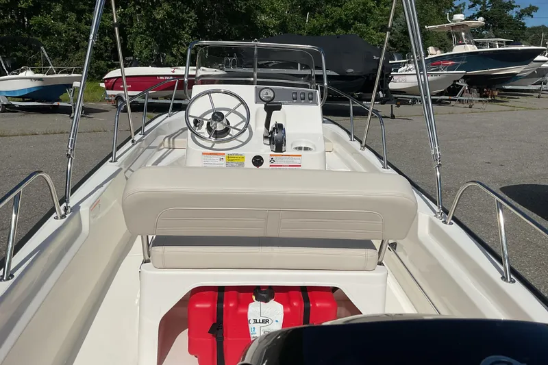 Slide: The Image of 2025 Boston Whaler 150 Montauk boat interior with steering wheel and seating. - 9