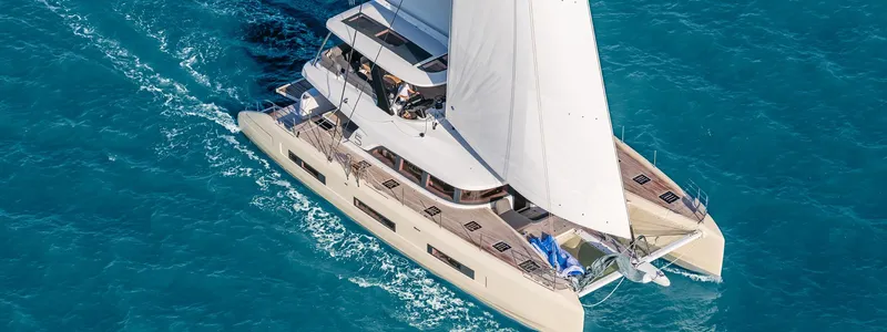 Slide: The Image of 2025 Lagoon SIXTY 5 catamaran sailing on clear blue ocean waters. - 0