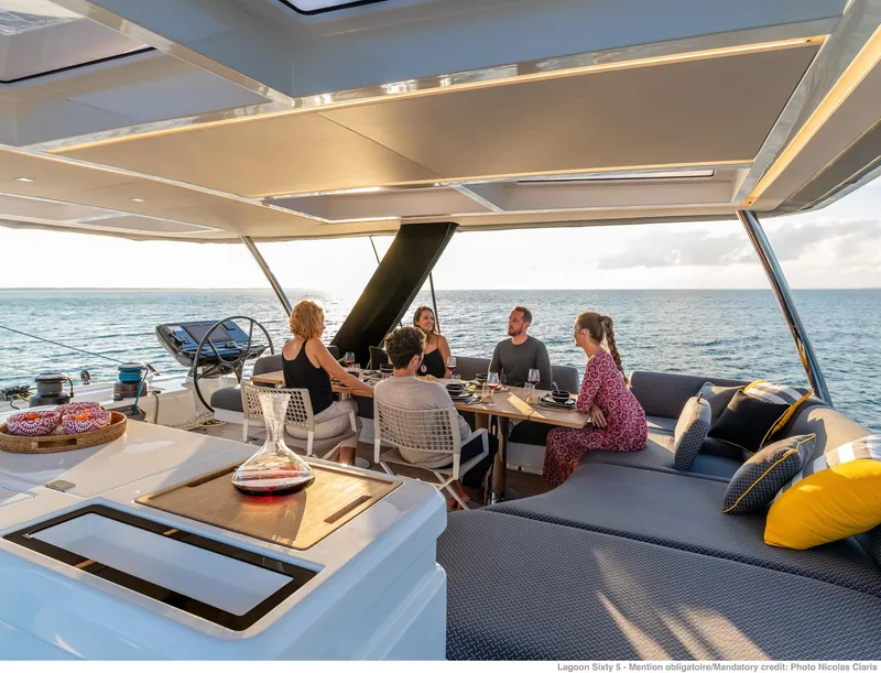 Slide: The Image of Luxurious Lagoon SIXTY 5 yacht, 2025 model, with people dining on deck at sunset. - 7
