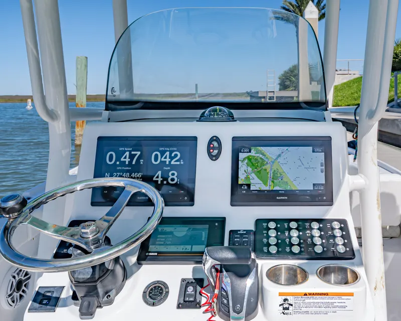 Slide: The Image of 2022 Caymas 26 HB boat dashboard with navigation screens and steering wheel. - 11