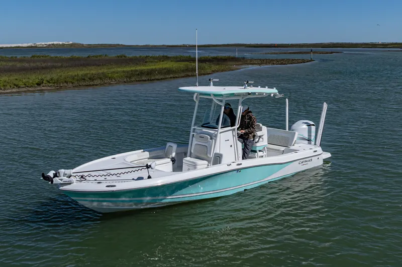 Slide: The Image of 2022 Caymas 26 HB boat cruising on a calm waterway under clear blue skies. - 5