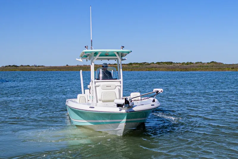 Slide: The Image of 2022 Caymas 26 HB boat navigating calm waters under clear blue skies. - 7