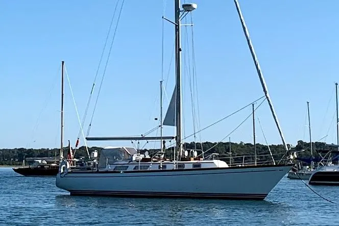 The Image of 1986 Bristol 38.8 sailboat on calm water, clear sky background. - 0