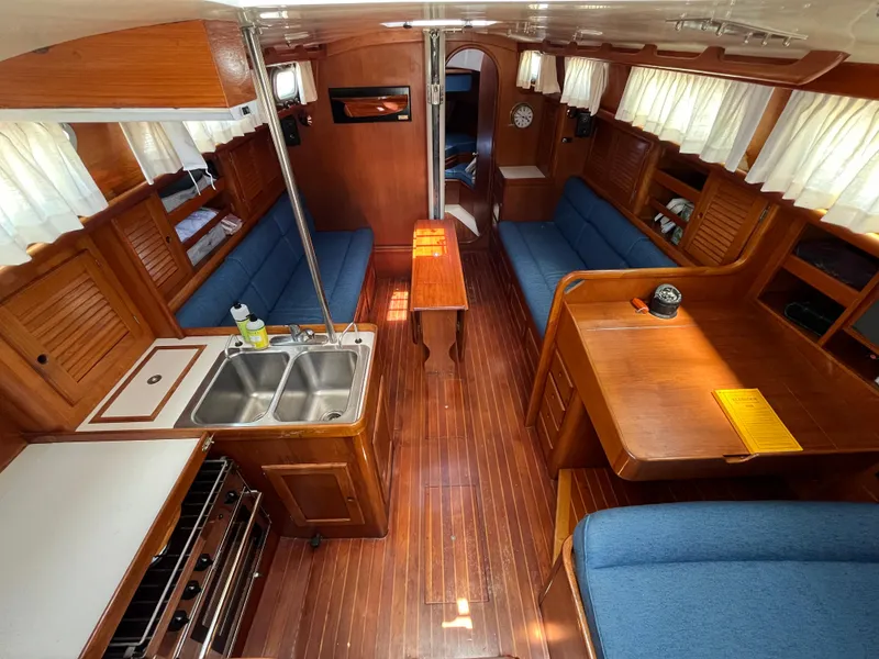 Slide: The Image of Interior of 1986 Bristol 38.8 sailboat with wood finish and blue seating. - 16