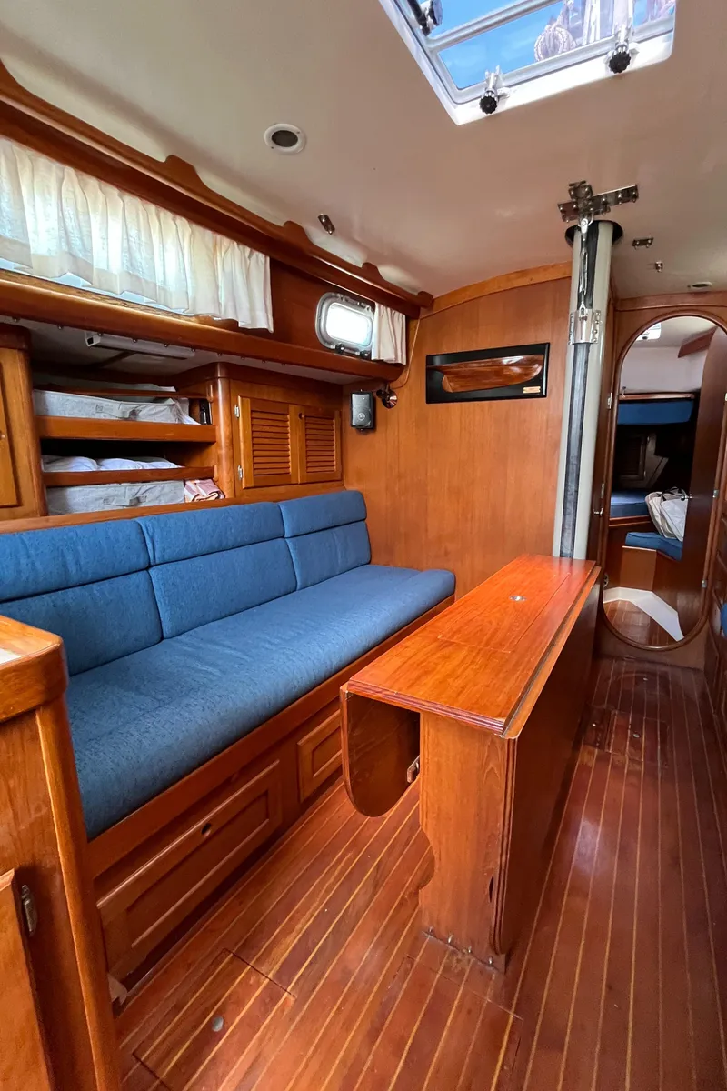 Slide: The Image of Interior of a 1986 Bristol 38.8 sailboat with wooden furnishings and blue seating. - 22
