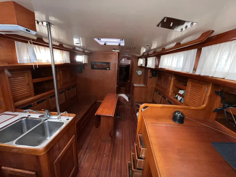 Slide: The Image of 1986 Bristol 38.8 yacht interior with wooden cabinetry, dining table, and dual sink. - 25