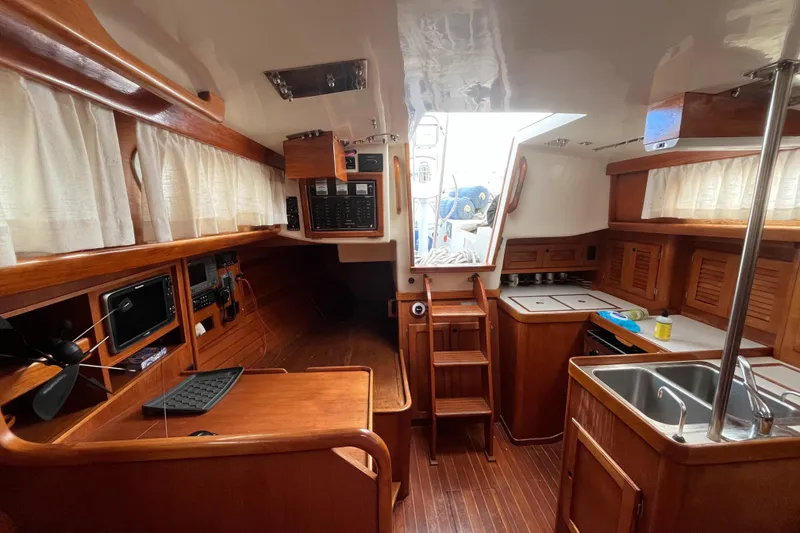 Slide: The Image of Interior of a 1986 Bristol 38.8 sailboat, featuring wood finishes and a compact kitchen. - 26