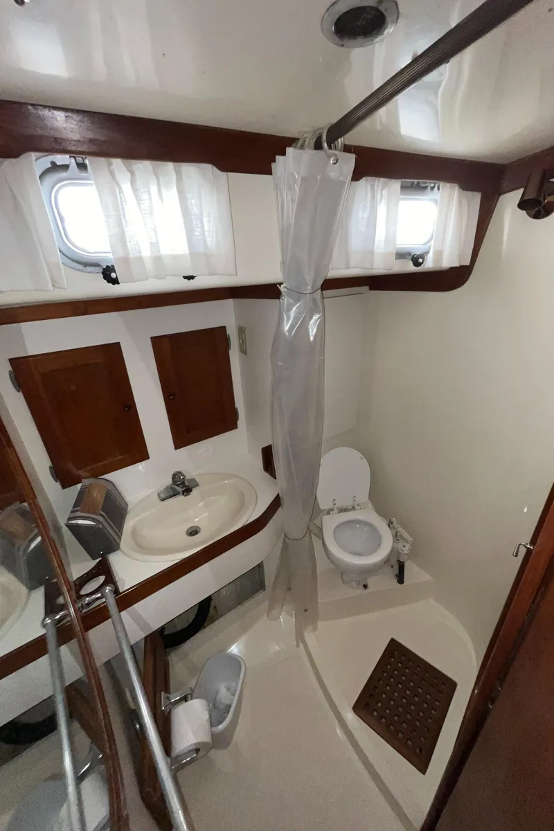 Slide: The Image of 1986 Bristol 38.8 yacht bathroom with sink, toilet, and shower curtain. - 28