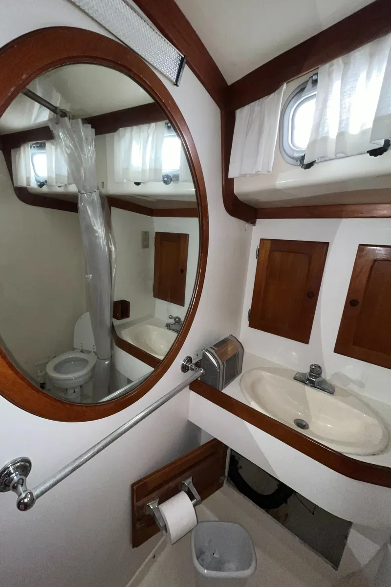 Slide: The Image of 1986 Bristol 38.8 yacht bathroom with sink, mirror, and wooden cabinets. - 29