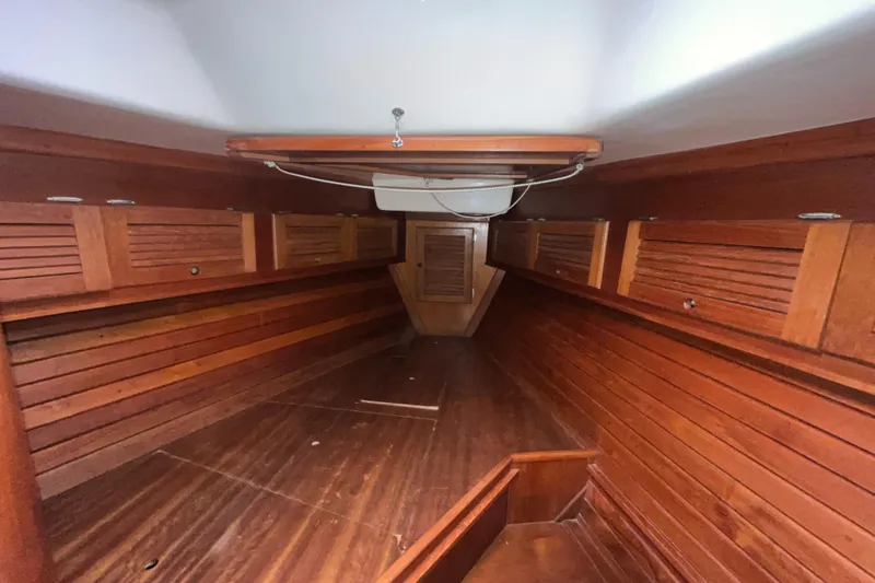 Slide: The Image of Interior of a 1986 Bristol 38.8 sailboat with wooden paneling and storage compartments. - 30