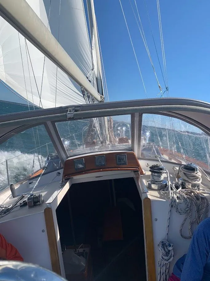 Slide: The Image of 1986 Bristol 38.8 sailboat cockpit with sails up, navigating on open water. - 5