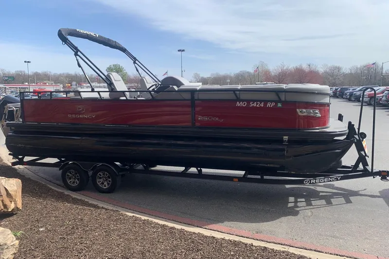 Slide: The Image of 2024 Regency R250DL3 pontoon boat on a trailer in a parking lot. - 3