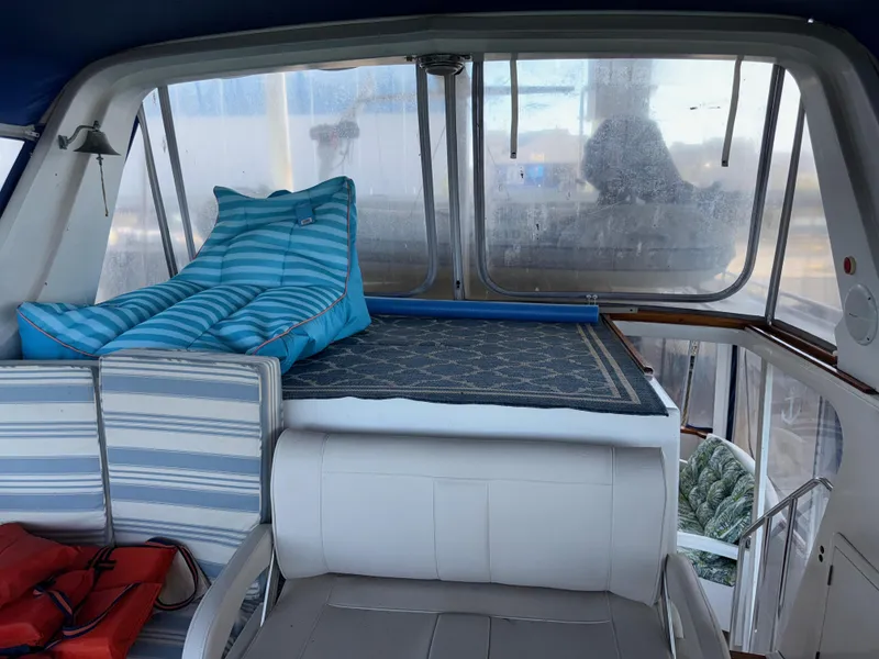 Slide: The Image of 1984 Marine Trader Sun Deck interior with striped cushions and seating area. - 13