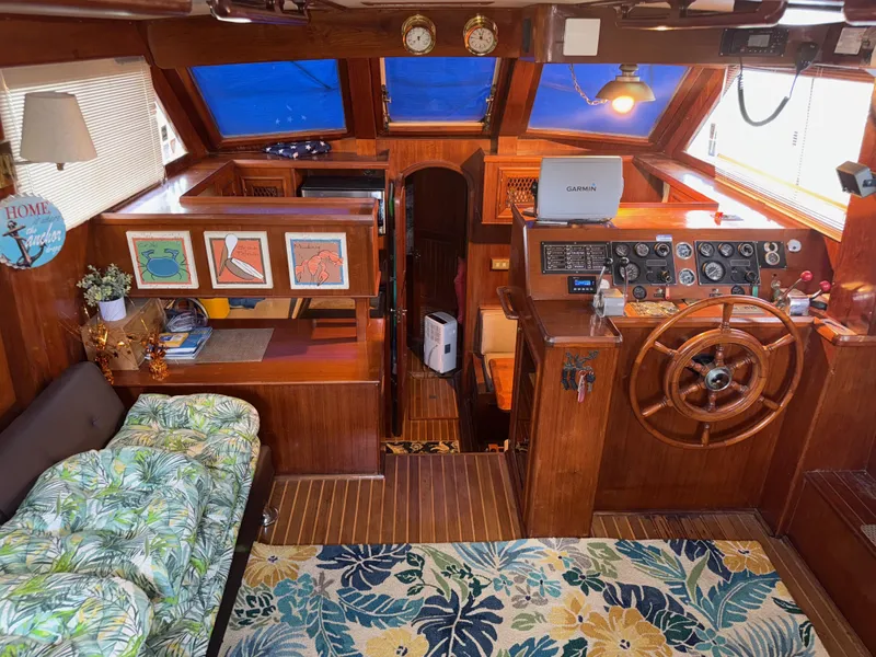 Slide: The Image of 1984 Marine Trader Sun Deck interior with wooden helm, floral decor, and nautical instruments. - 14