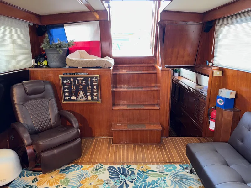 Slide: The Image of 1984 Marine Trader Sun Deck interior with wooden paneling, seating, and nautical decor. - 23