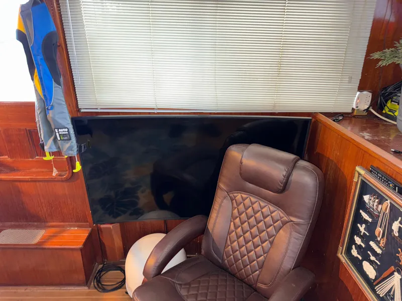 Slide: The Image of 1984 Marine Trader Sun Deck interior with leather chair, TV, and nautical decor. - 24