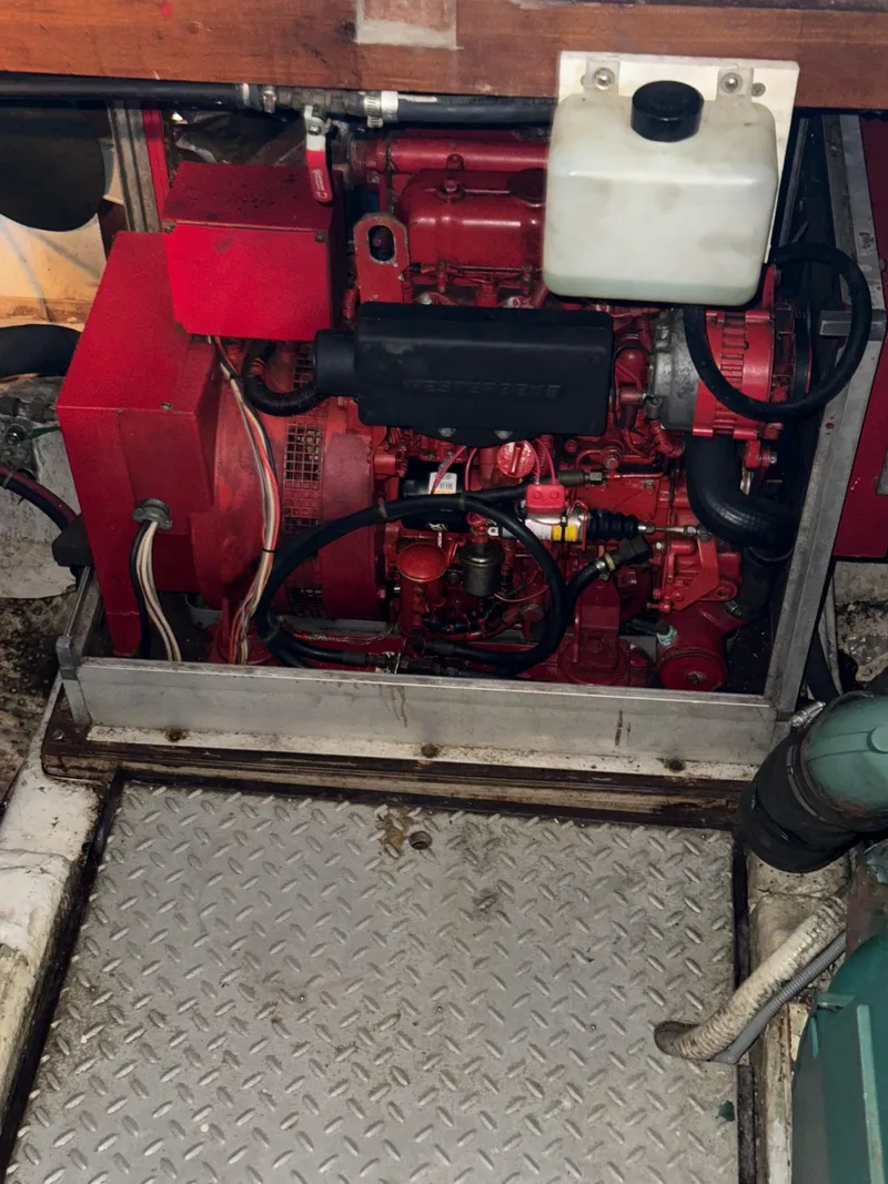 Slide: The Image of 1984 Marine Trader Sun Deck engine compartment with red machinery and metal flooring. - 31