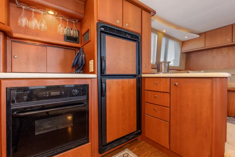 Slide: The Image of 2005 Silverton 43 Motor Yacht kitchen with wood cabinetry, oven, and refrigerator. - 27