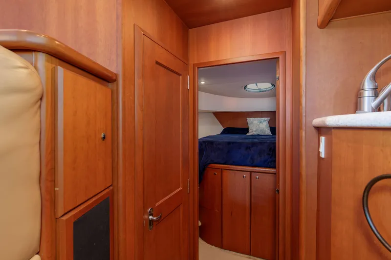 Slide: The Image of Interior of 2005 Silverton 43 Motor Yacht with wood paneling and cozy bedroom. - 31