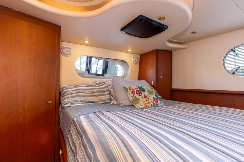 Slide: The Image of Interior of 2005 Silverton 43 Motor Yacht bedroom with striped bedding and decorative pillows. - 34