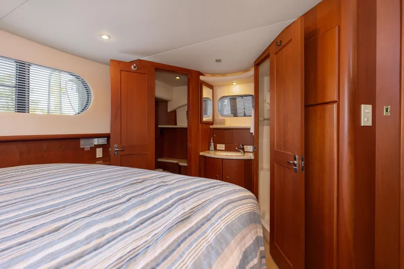 Slide: The Image of Interior of 2005 Silverton 43 Motor Yacht bedroom with wood finishes and striped bedding. - 35