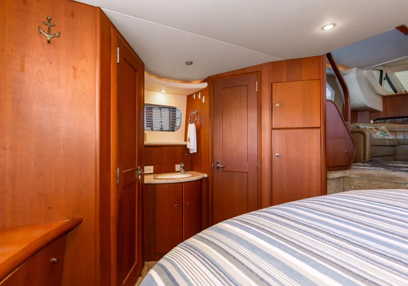 Slide: The Image of Interior of 2005 Silverton 43 Motor Yacht with wood cabinetry and striped bedding. - 36