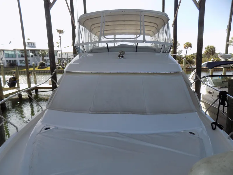 Slide: The Image of 2005 Silverton 43 Motor Yacht docked, featuring covered flybridge and sleek design. - 55