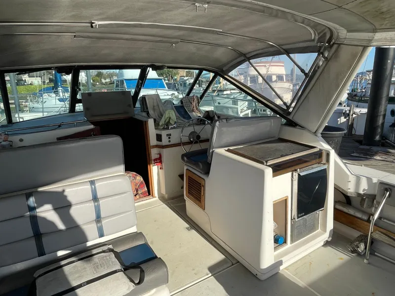 Slide: The Image of 1986 Tiara Yachts 3100 Open interior with helm, seating, and marina view. - 1