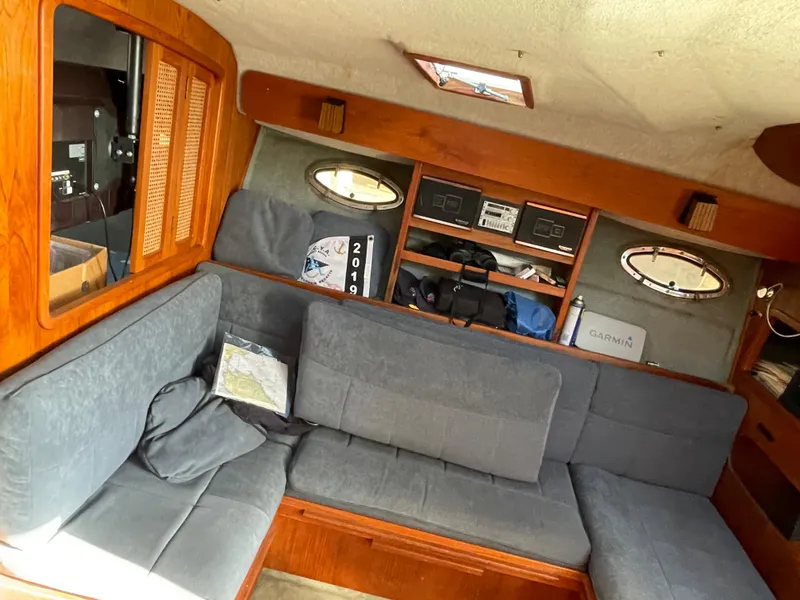 Slide: The Image of 1986 Tiara Yachts 3100 Open interior with gray seating and wooden accents. - 2