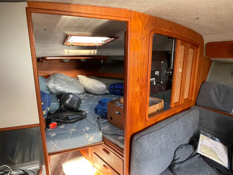 Slide: The Image of 1986 Tiara Yachts 3100 Open cabin interior with bed, storage, and seating area. - 3