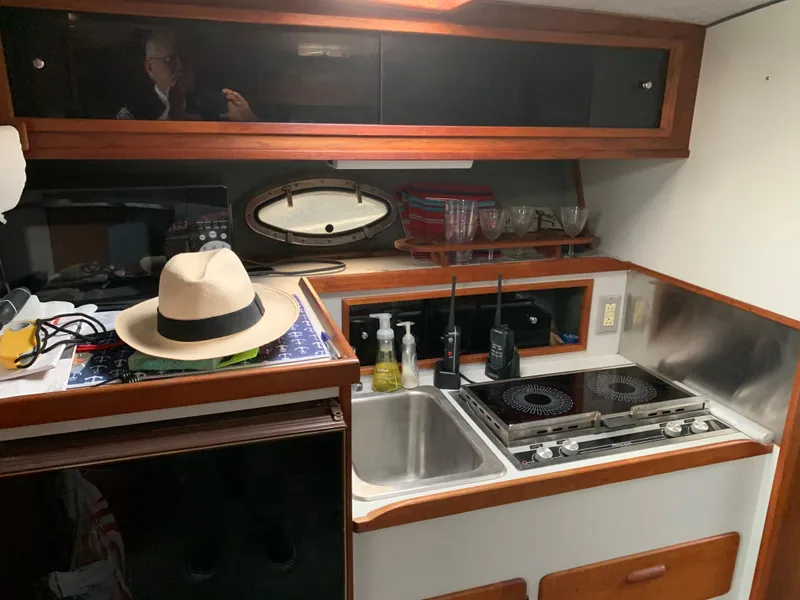 Slide: The Image of 1986 Tiara Yachts 3100 Open galley with stove, sink, and storage cabinets. - 5